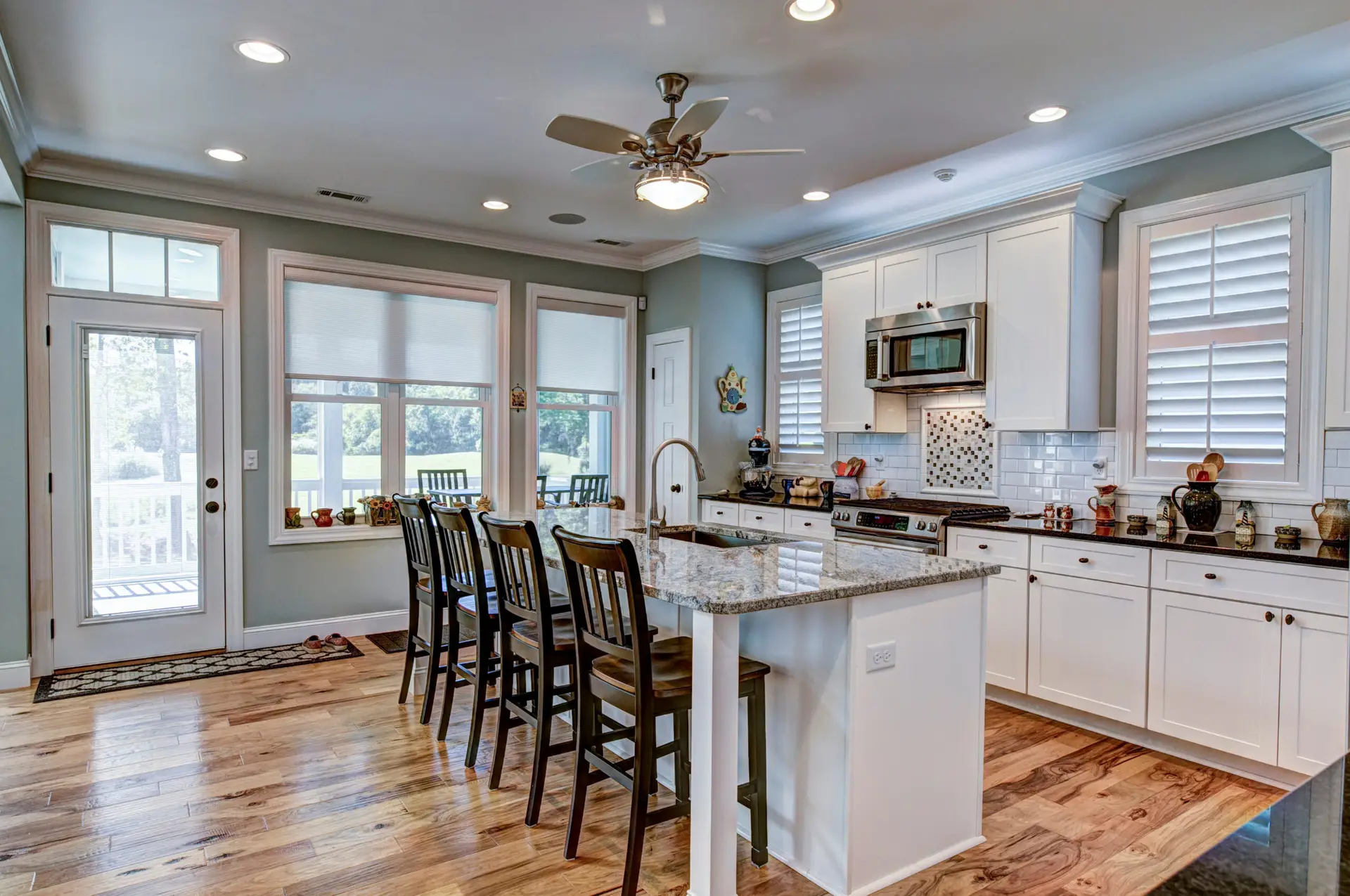 Open concept kitchen remodel in Vancouver with large granite island, barstools, and custom cabinetry